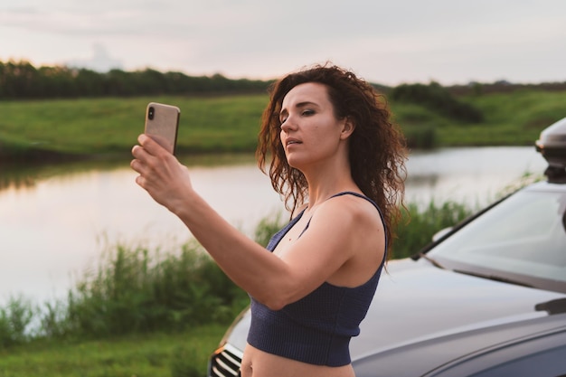 Young woman travelers are photographed on a smartphone in nature