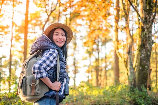 Young woman traveller with backpack in a woods