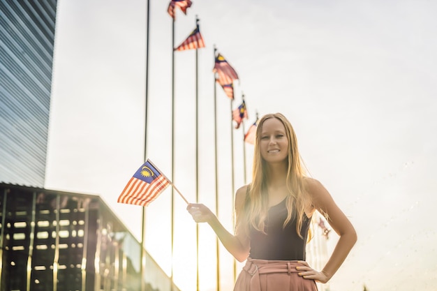 Young woman travels in Malaysia Holds the Malaysian flag