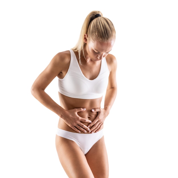 A young woman in underwear holds her stomach because of menstrual gallbladder abdominal appendix or abdominal pain Isolated on White