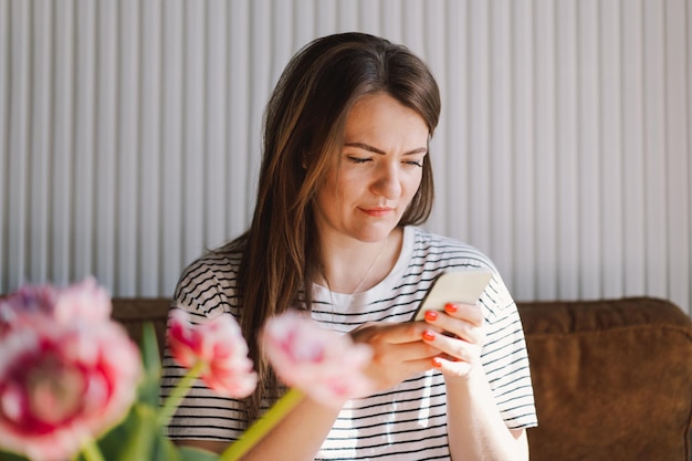 Young woman use mobile phone Drink coffee and sit alone at table in coffee shop