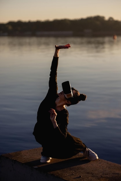 Young woman uses virtual or augmented reality glasses in magic atmosphere of dawn rays, female VR