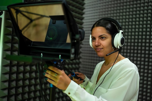 Young woman using a broadcast camera on set