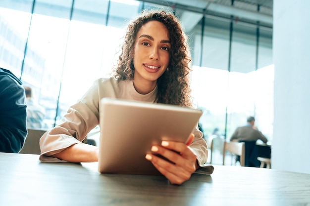 Young woman using digital tablet at cafe