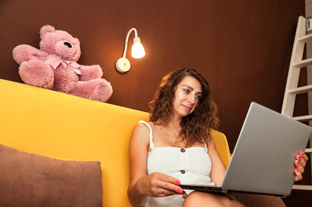 Young woman using laptop in living room at home distant work online shopping or education