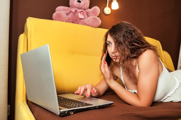 Young woman using laptop in living room at home distant work online shopping or education