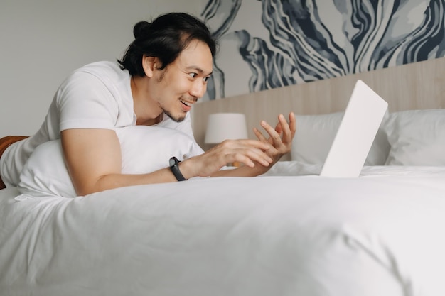 Young woman using laptop while lying on bed at home