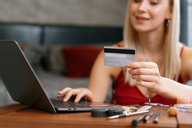 Young woman using laptop with credit card for internet banking blithe