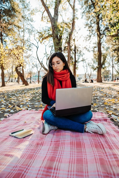 young woman using laptop to work outdoors