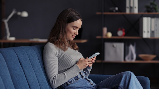 Young woman using mobile phone apps, texting message