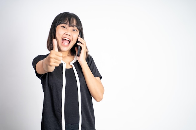 Young woman using mobile phone with thumbs up