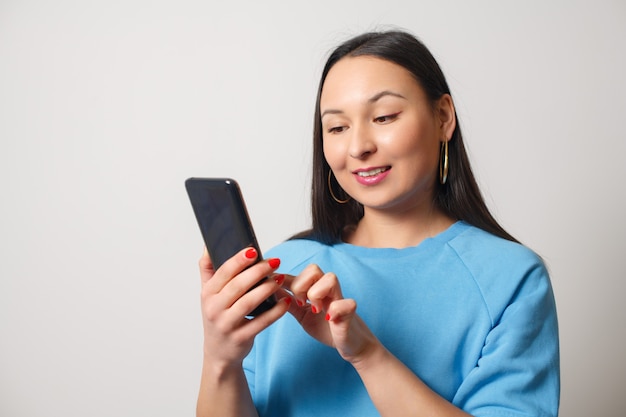 Young woman using a smartphone. On a white background.