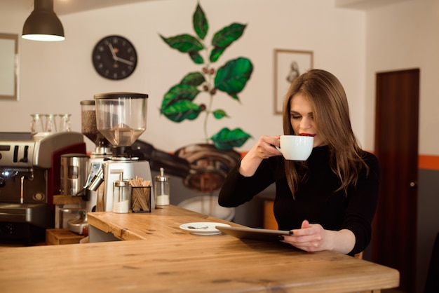 Young woman using tablet computer in a cafe.