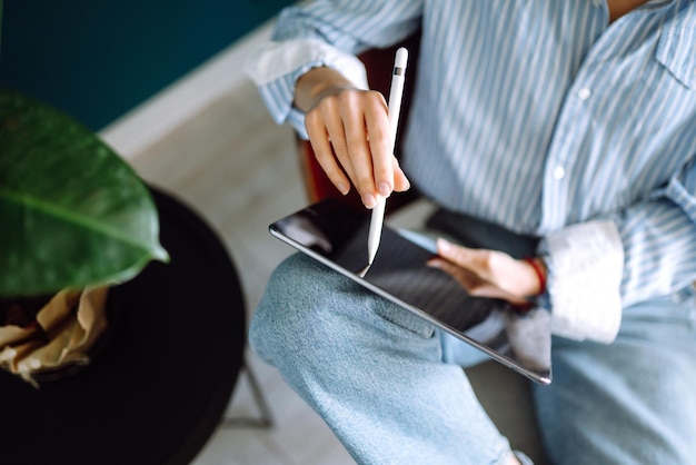 Young woman using tablet spending leisure time chatting in social network