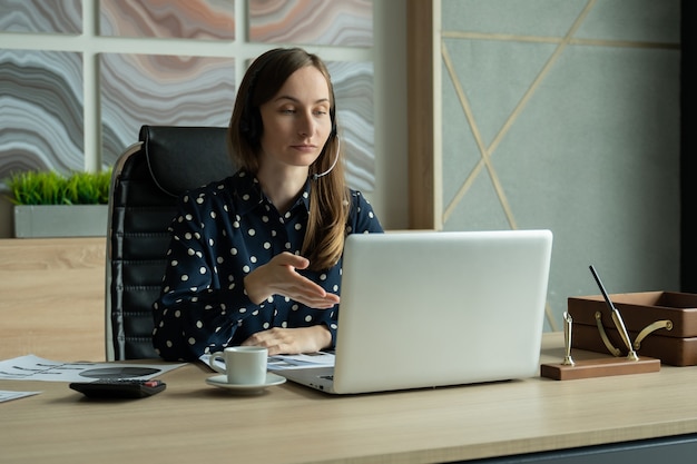 Young woman using video chat on laptop in office