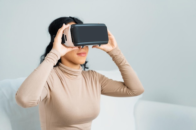 Young woman using virtual reality VR goggle at home for crucial online shopping experience The virtual reality VR innovation optimized for female digital entertainment lifestyle