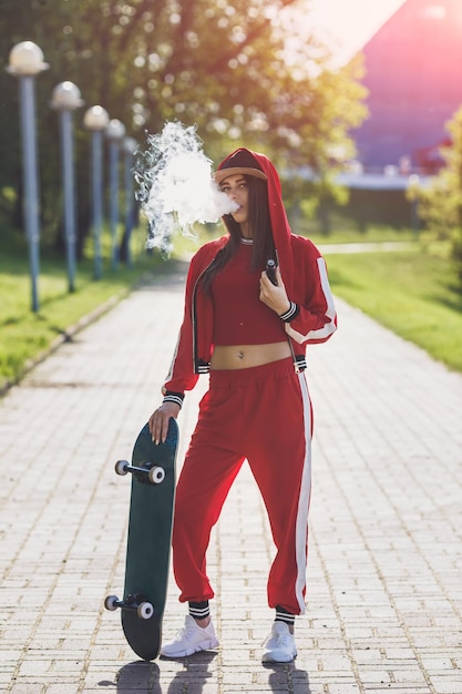 Young woman vape ecig pretty young female in black hat red clothing vape ecig