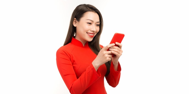 Young woman in vietnamese traditional dressing show smart phone in her hand