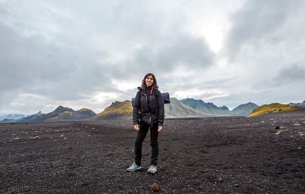 A young woman in volcanic ash and a green mountain. Landmannalaugar, Iceland