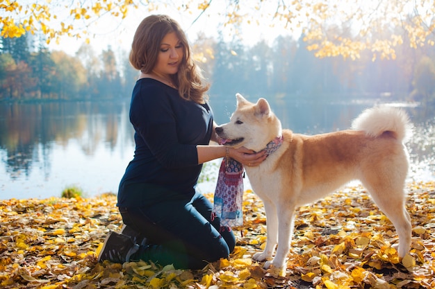 Young woman on a walk with her dog breed Akita inu