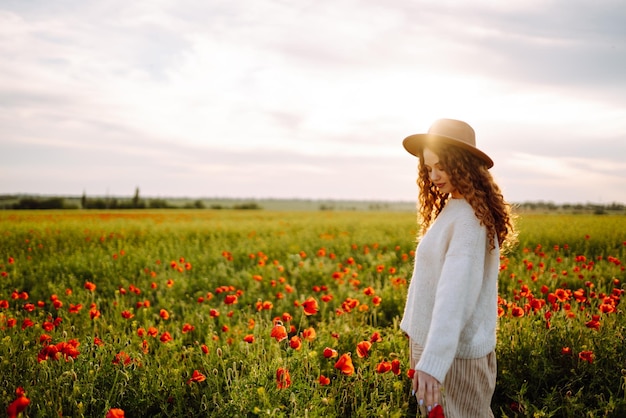 Young woman walking in amazing poppy field Nature vacation relax and lifestyle