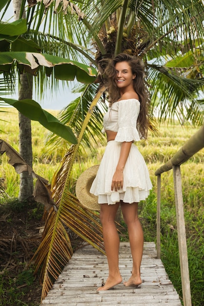 Young woman walking by old wooden bridge in the countryside