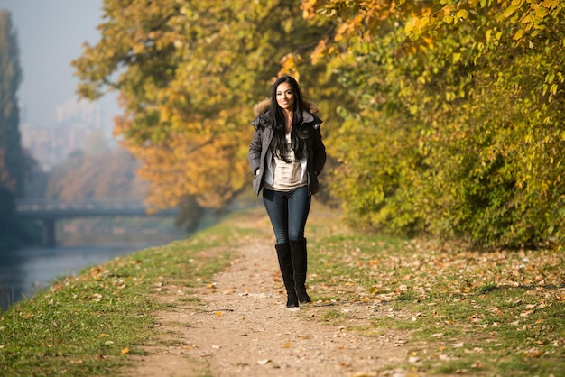 Young Woman Walking In Forest Through The Woods Outside During Autumn