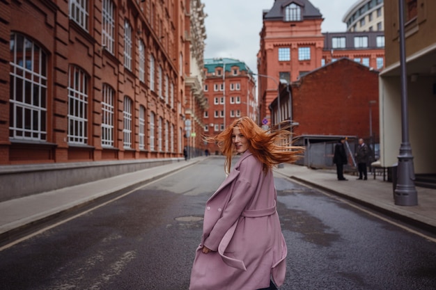 Young woman walking through Moscow streets. Walking on promenade. Gorky Park in early spring or autumn