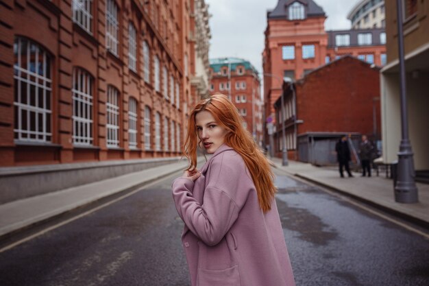 Young woman walking through Moscow streets. Walking on promenade. Gorky Park in early spring or autumn