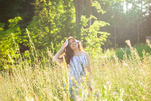 Young woman walking among wildflowers on sunny summer day concept of the joy of communicating with