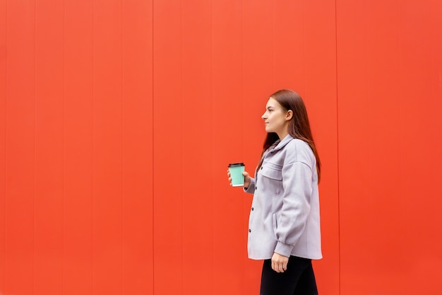 Young woman walking with glass of coffee