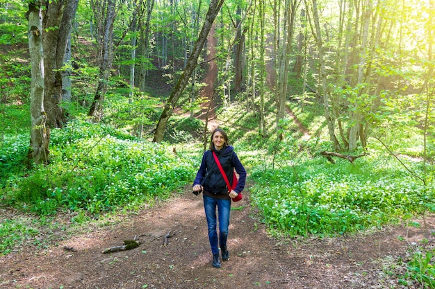 A young woman walks in the forest on a spring day