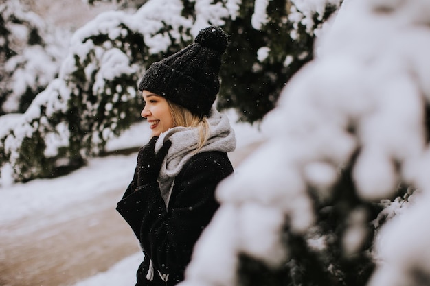 Young woman in warm clothes enjoying in snow