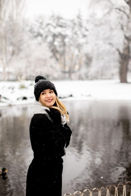 Young woman in warm clothes enjoying in snow