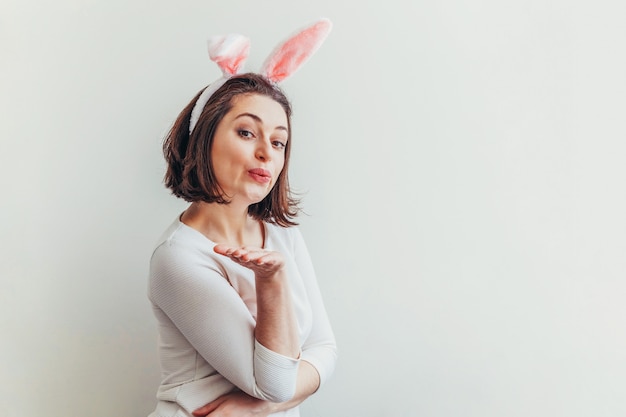 Young woman wearing bunny ears isolated on white background.