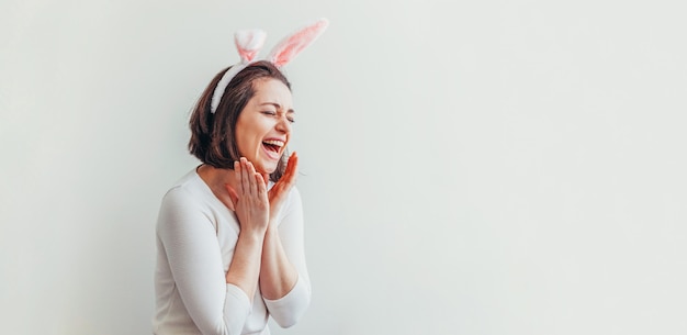 Young woman wearing bunny ears isolated on white background.