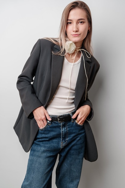 Photo young woman wearing a grey blazer white tank top and jeans