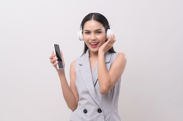 A young woman wearing headphones enjoying with music on white background