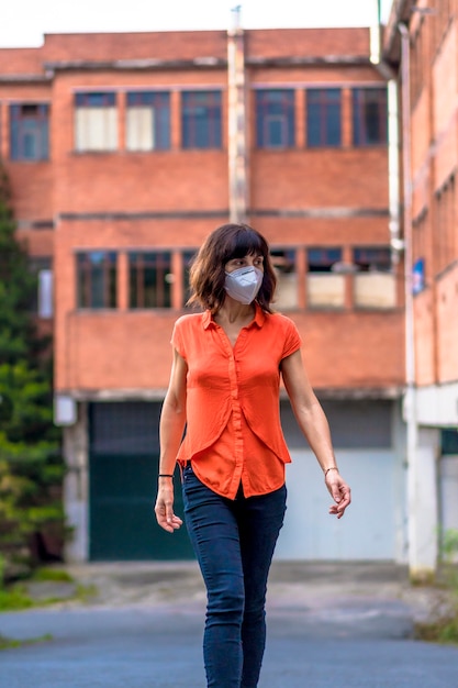 Young woman wearing a mask in the street. Coronavirus prevention