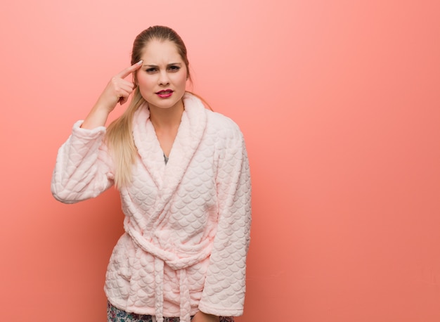 Young  woman wearing pajama doing a disappointment gesture with finger