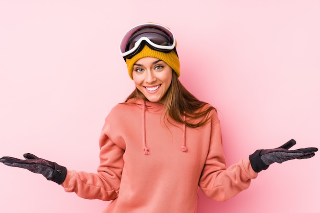 Photo young woman wearing a ski clothes showing a welcome expression.