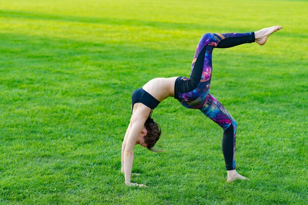 Young woman wearing sportswear doing yoga with deflection back