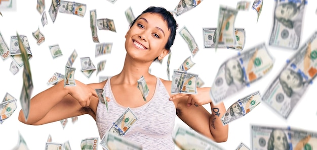 Young woman wearing sportswear looking confident with smile on face, pointing oneself with fingers proud and happy.