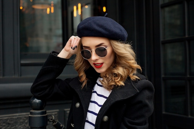 Young woman wearing stylish classic clothes and sunglasses