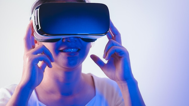 Young woman wearing virtual reality headset exciting on Metaverse experience