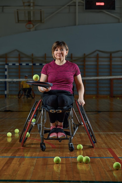 Young woman on wheelchair playing tennis on tennis court