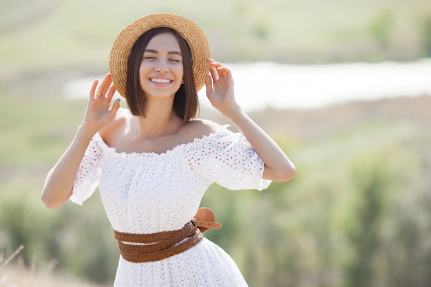 Young woman in a white dress and hat