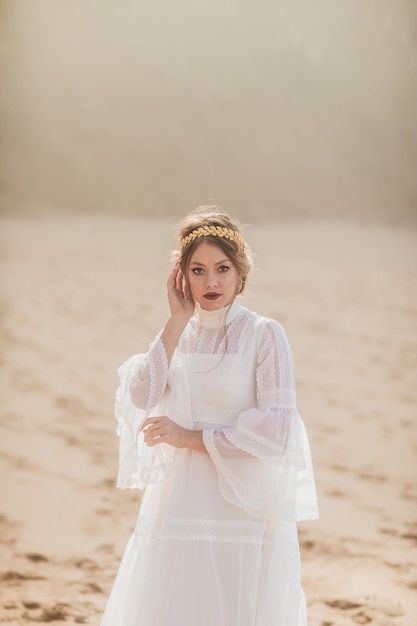 young woman in white dress walking at the beach