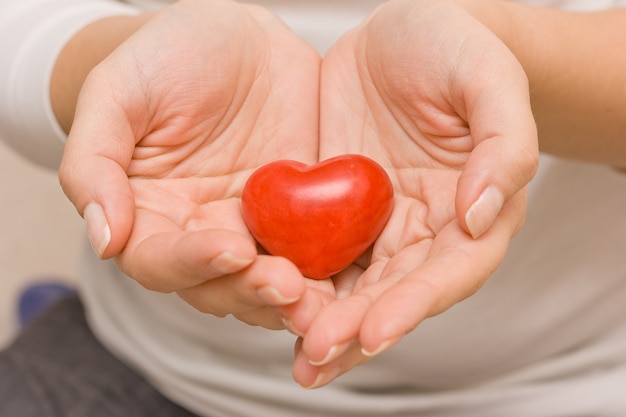 young woman in a white tshirt holding a big organic pomegranate in her hand