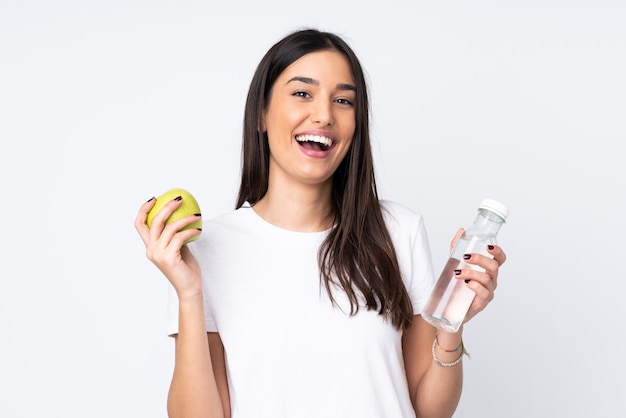 Young woman on white with an apple and with a bottle of water